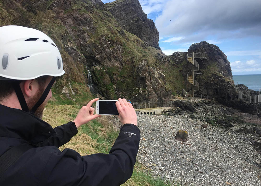 Visitor photographing The Gobbins path entrance on a mobile phone